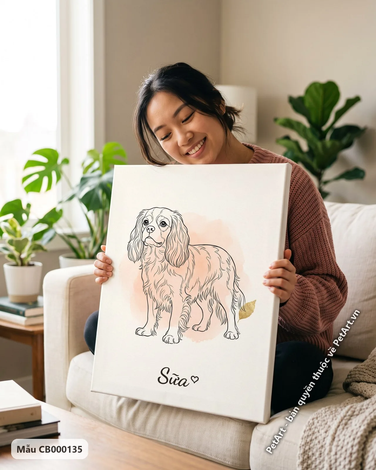 Ảnh thực tế: Chó Cavalier đứng thẳng, phác họa nét đen tối giản, trên nền hồng nhạt cùng chiếc lá vàng nhỏ.