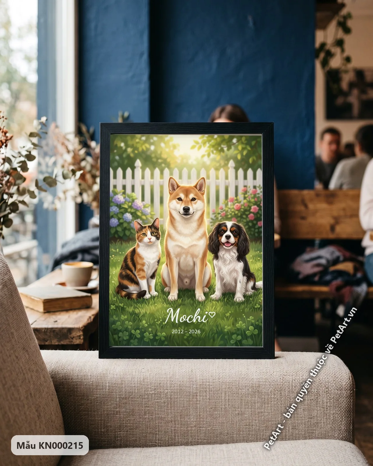 Ảnh thực tế: Chó Shiba vui vẻ, mèo tam thể và chó Cavalier đáng yêu ngồi trên thảm cỏ xanh mướt trong vườn hàng rào trắng.