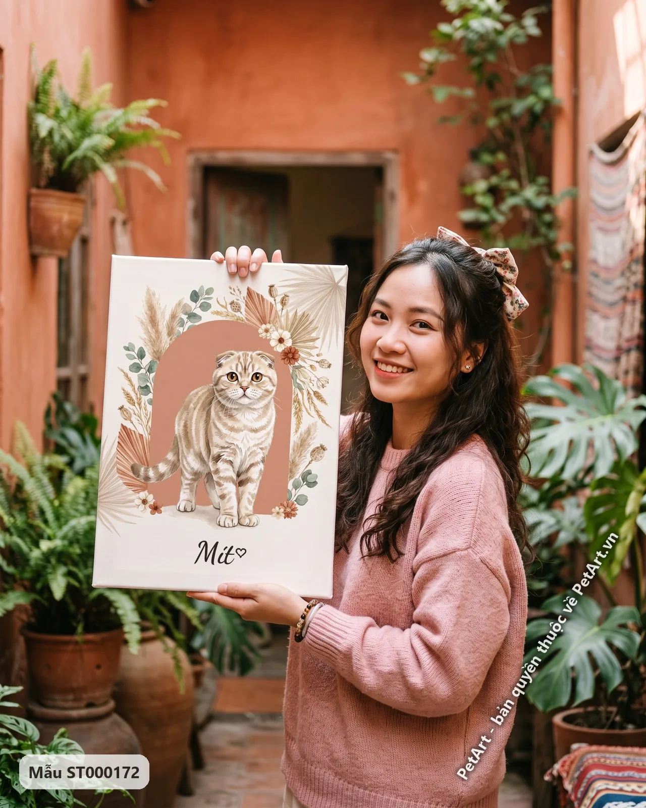Ảnh thực tế: Mèo tai cụp vằn kem đứng thẳng trong khung vòm hoa lá khô phong cách Boho, nền màu be nhạt.